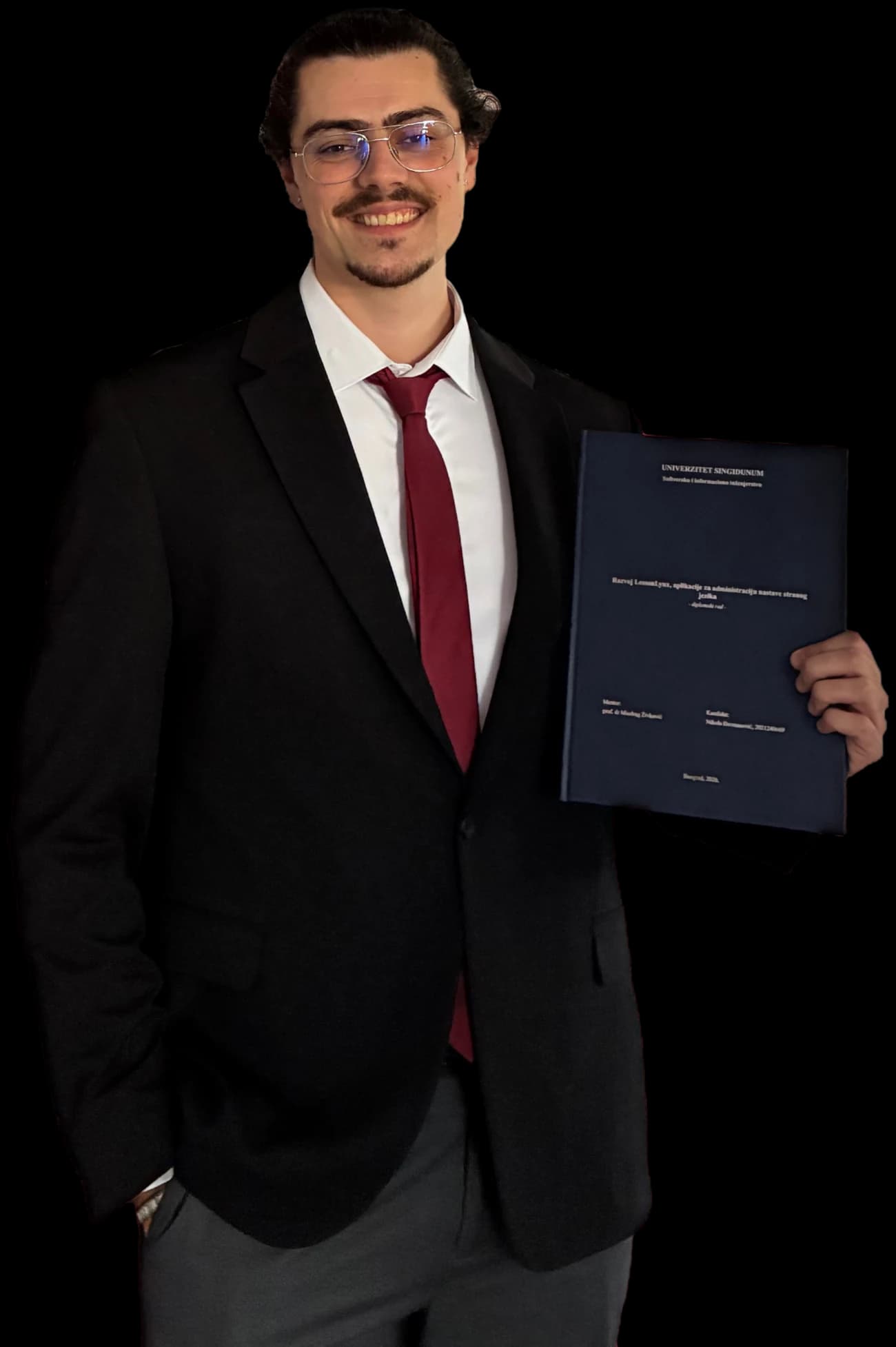 Nikola Djermanovic in a suit, smiling, holding his bound bachelor's thesis on LessonLynx Mobile
